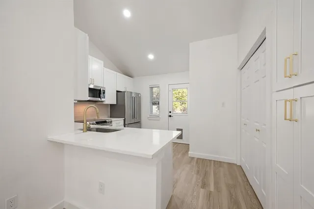 a kitchen with kitchen island a sink appliances and cabinets