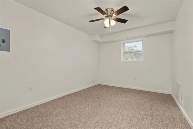 an empty room with a window and a fan