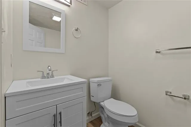 a bathroom with a toilet a sink and mirror