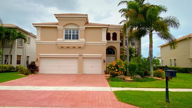 a front view of a house with a yard and trees