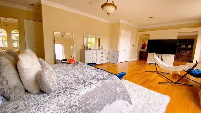 a bedroom with a bed and wooden floor