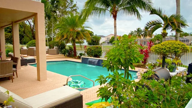 a view of a house with a small yard and a palm tree