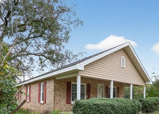 a front view of a house with plants