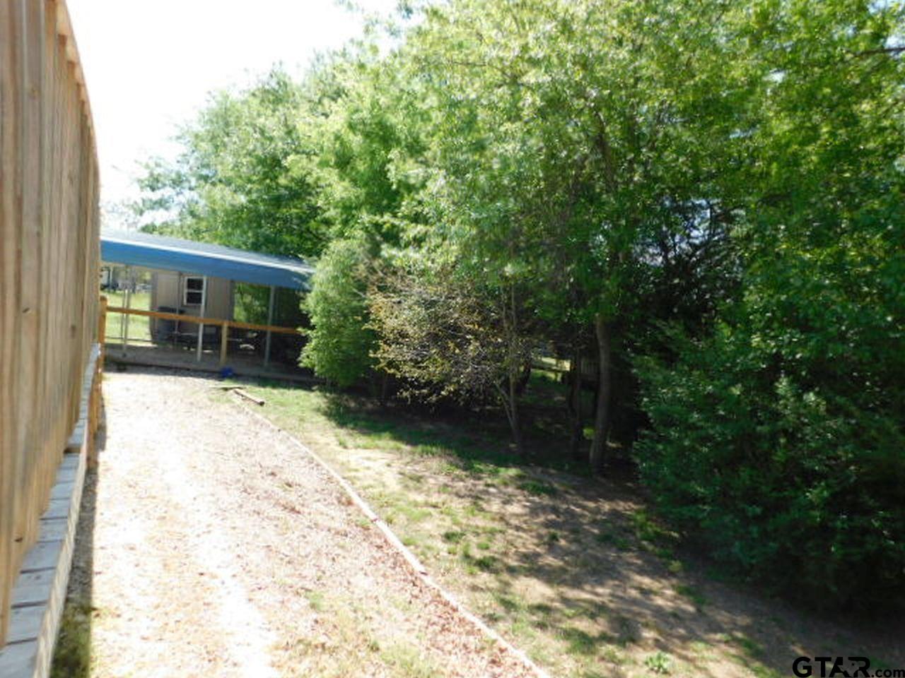 285 Caddo Quitman, TX 75783 - Photo 2 of 14 a view of house with backyard and trees
