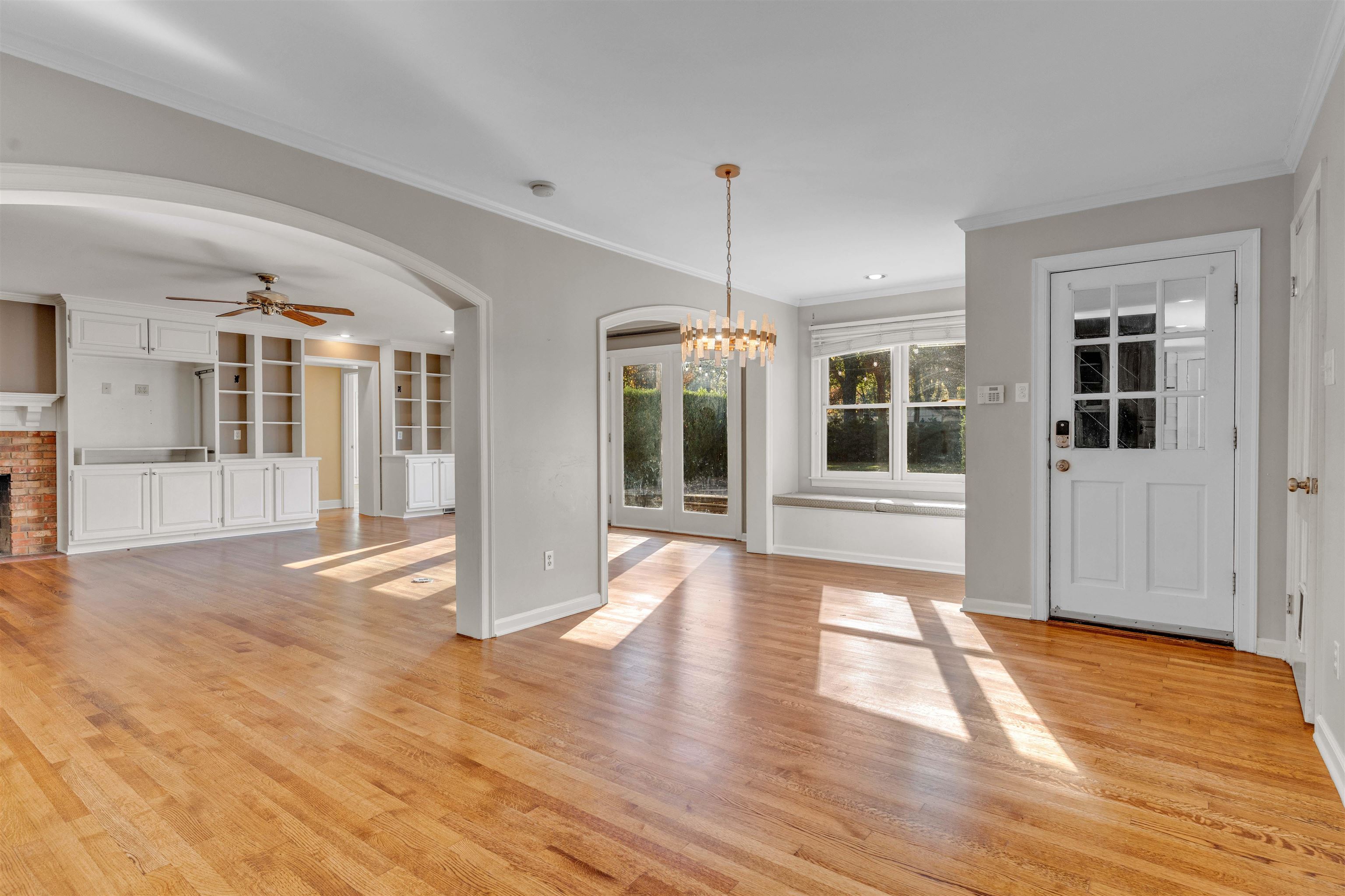 2014 Heather Cove Memphis, TN 38119 - Photo 11 of 40 Unfurnished dining area with ornamental molding, light wood-style flooring, a ceiling fan, a chandelier, and a brick fireplace