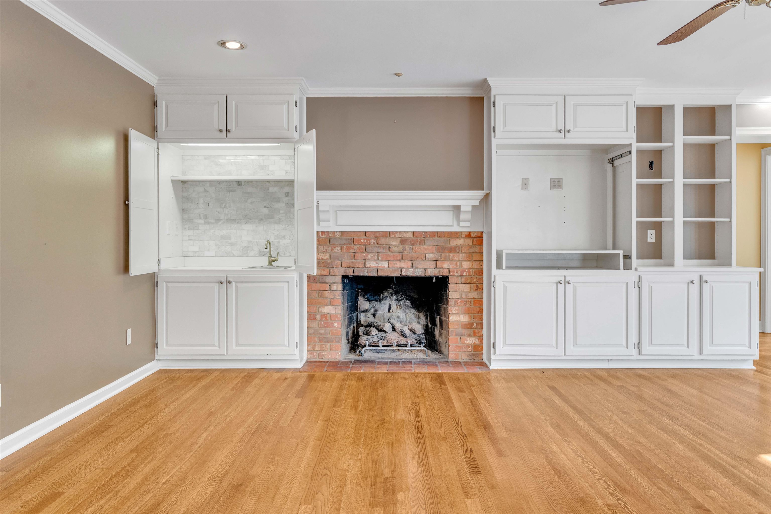 2014 Heather Cove Memphis, TN 38119 - Photo 13 of 40 Unfurnished living room featuring a brick fireplace, a ceiling fan, light wood-style floors, crown molding, and recessed lighting