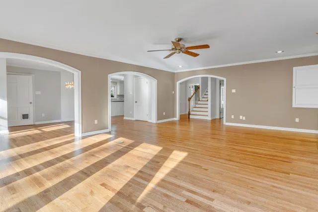 a view of a livingroom with wooden floor and a ceiling fan