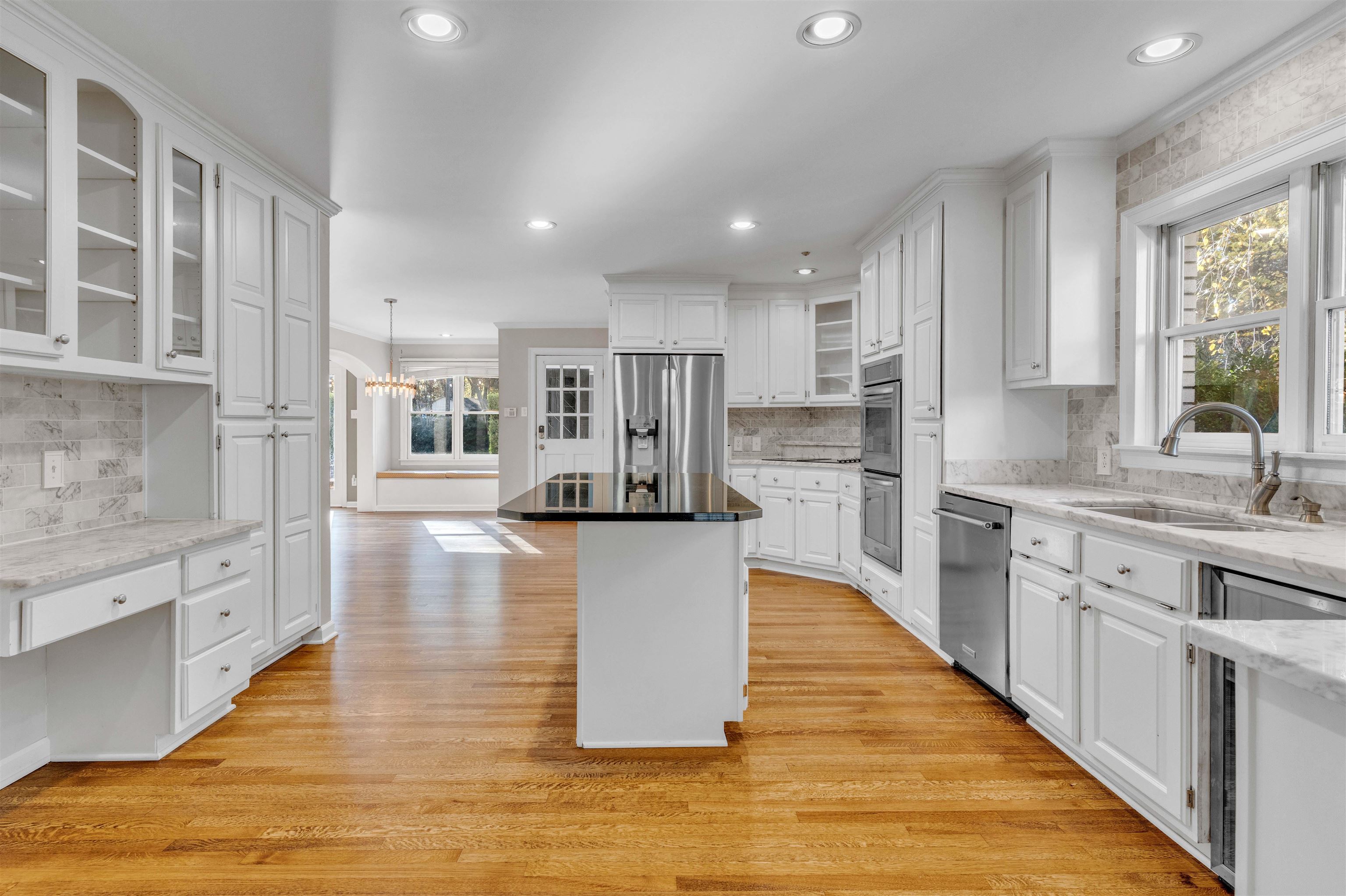 2014 Heather Cove Memphis, TN 38119 - Photo 22 of 40 Kitchen featuring glass insert cabinets, tasteful backsplash, white cabinetry, light wood-type flooring, and dark stone counters