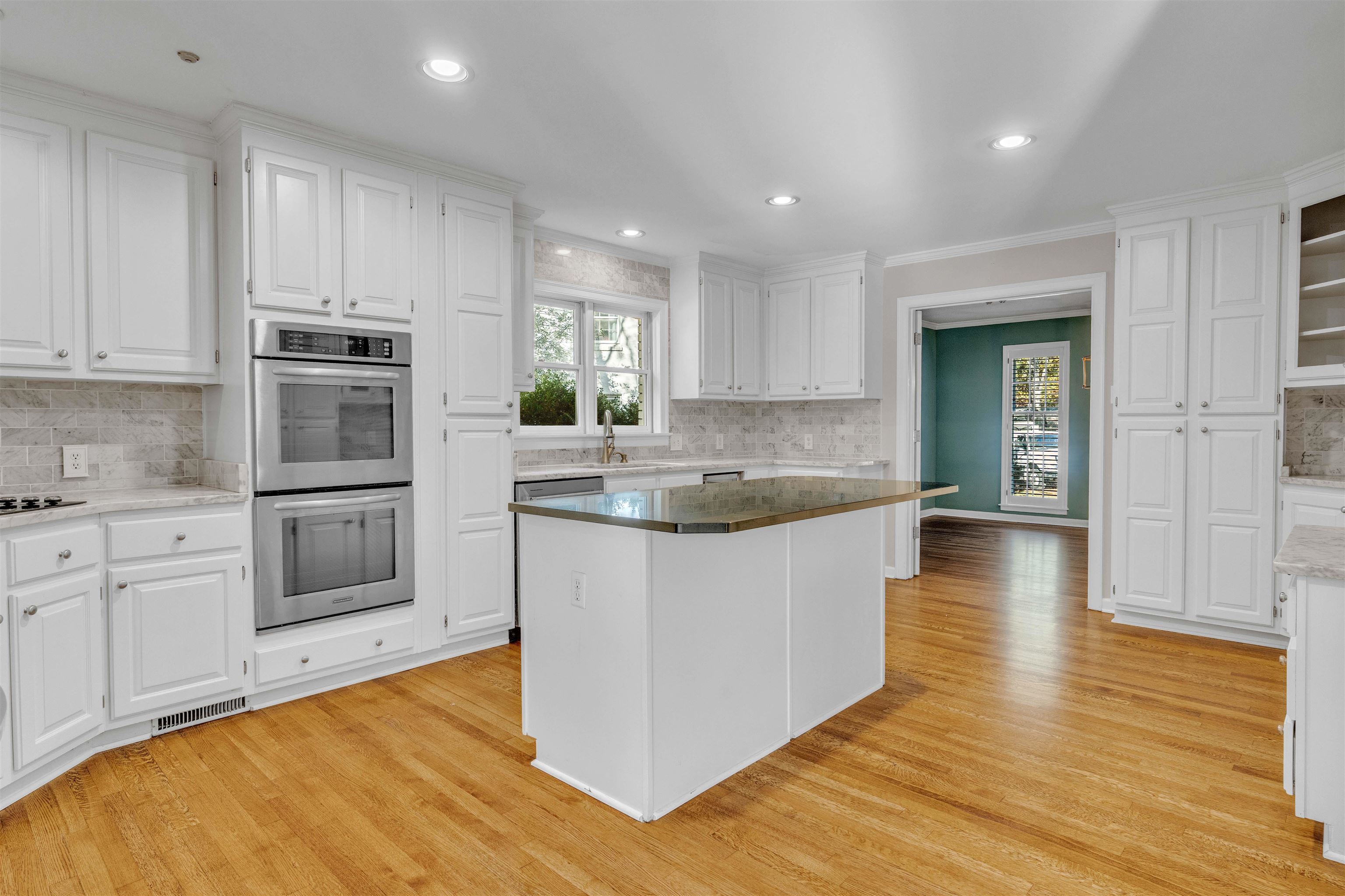 2014 Heather Cove Memphis, TN 38119 - Photo 23 of 40 Kitchen with tasteful backsplash, white cabinets, double oven, ornamental molding, and light wood-type flooring