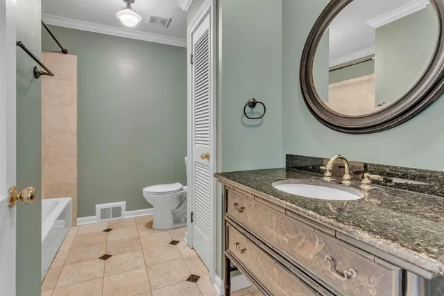 a bathroom with a granite countertop toilet a sink and a mirror