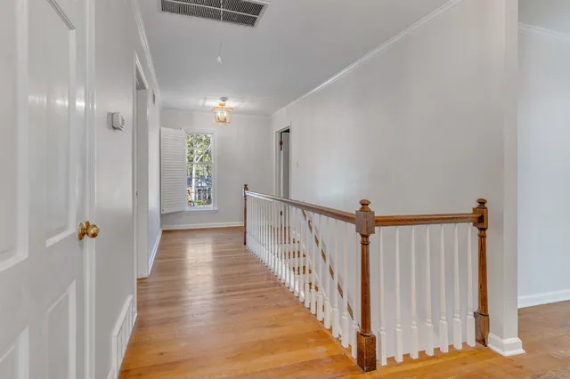 a view of a hallway with wooden floor and staircase