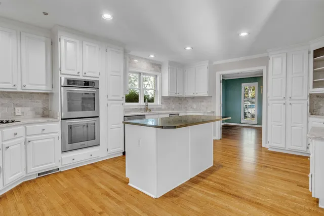 a kitchen with stainless steel appliances granite countertop a stove a sink and a refrigerator
