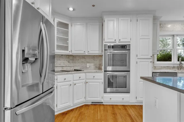 a kitchen with white cabinets and stainless steel appliances