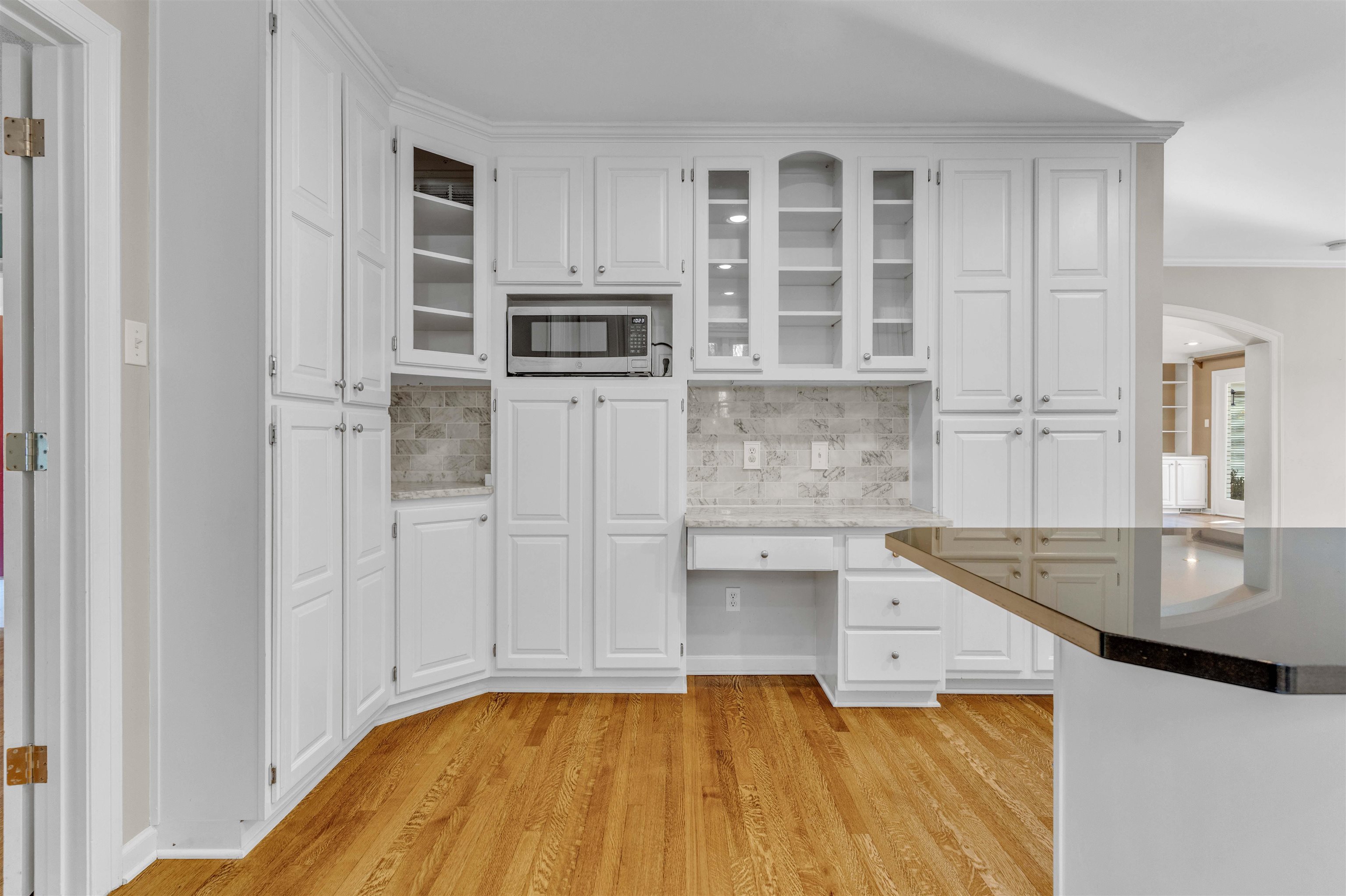 2014 Heather Cove Memphis, TN 38119 - Photo 10 of 40 Kitchen with built in study area, glass insert cabinets, white cabinetry, decorative backsplash, and crown molding