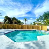 a view of a house with backyard and a tree