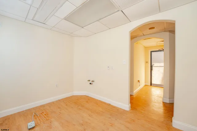a large white kitchen with a sink and a wooden floor