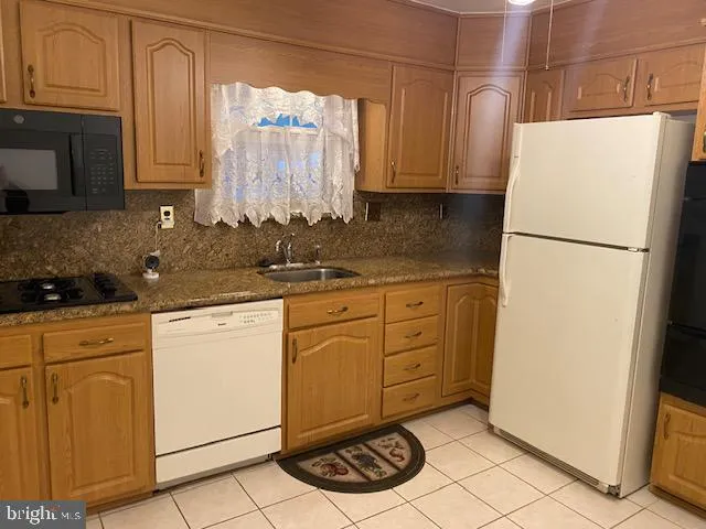 a kitchen with stainless steel appliances a sink and a refrigerator