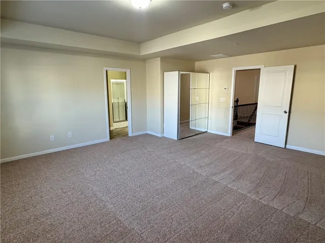a view of an empty room with closet and wooden floor