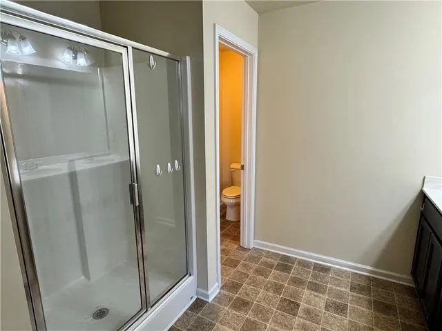 a bathroom with a glass door shower and a sink
