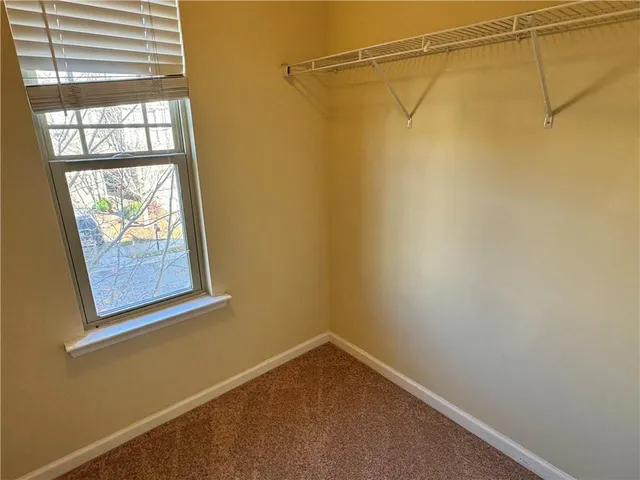 a view of a small space with racks on the wall and a window