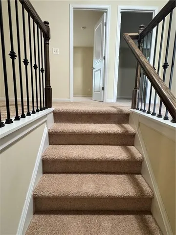 a view of staircase with lots of frames on wall