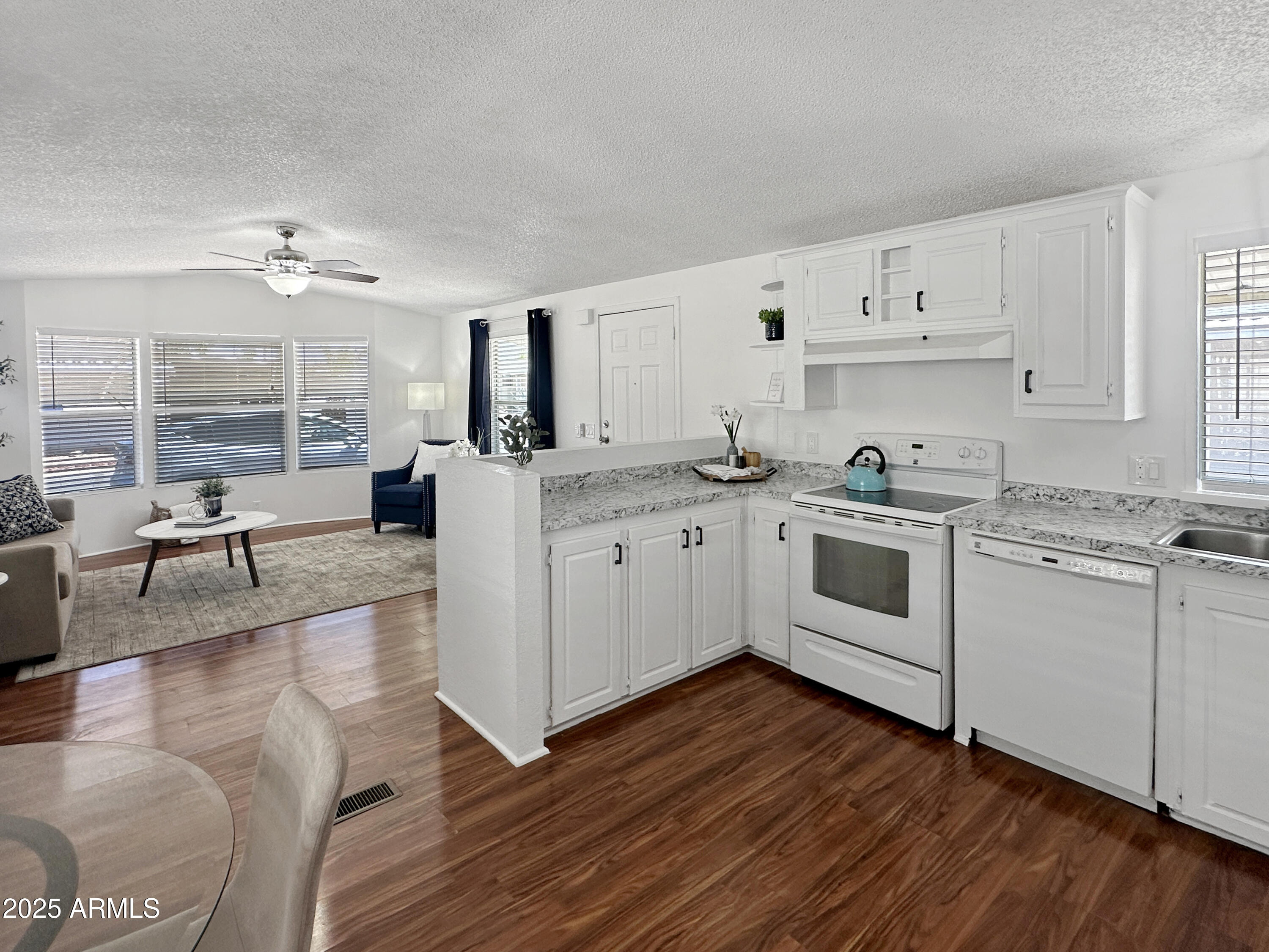 834 South Meridian Road, Unit 164 Apache Junction, AZ 85120 - Photo 7 of 16 a kitchen with a sink cabinets wooden floor and a view of living room