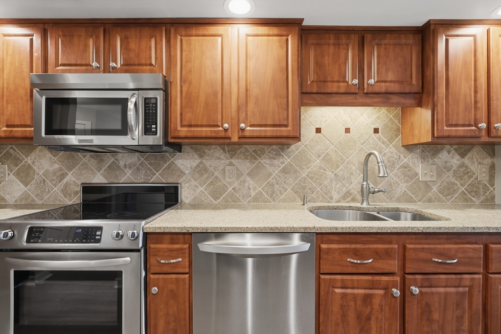 68 South Quinsigamond Avenue, Unit 4 Shrewsbury, MA 01545 - Photo 11 of 37 a kitchen with granite countertop wood cabinets and stainless steel appliances