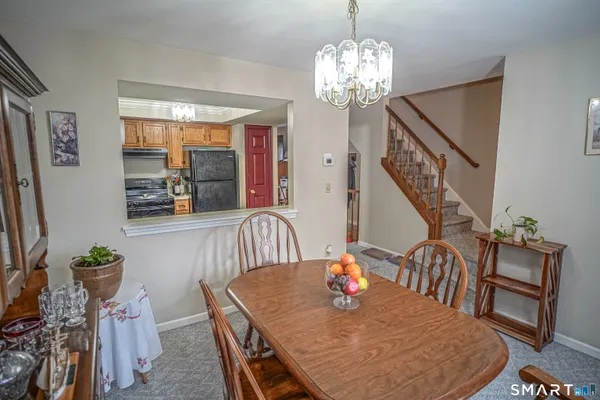 a view of a dining room with furniture a chandelier and wooden floor