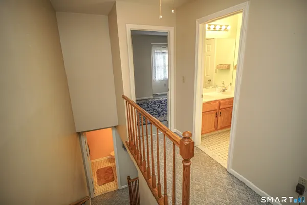 a view of a hallway with wooden floor and staircase