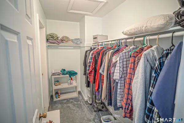 a view of walk in closet with clothes and shoes