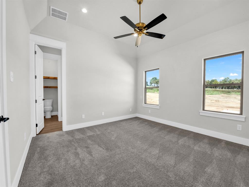 3025 West Frk Way Springtown, TX 76082 - Photo 14 of 26 an empty room with windows and fan