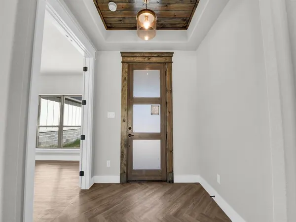 a view of empty room with wooden floor