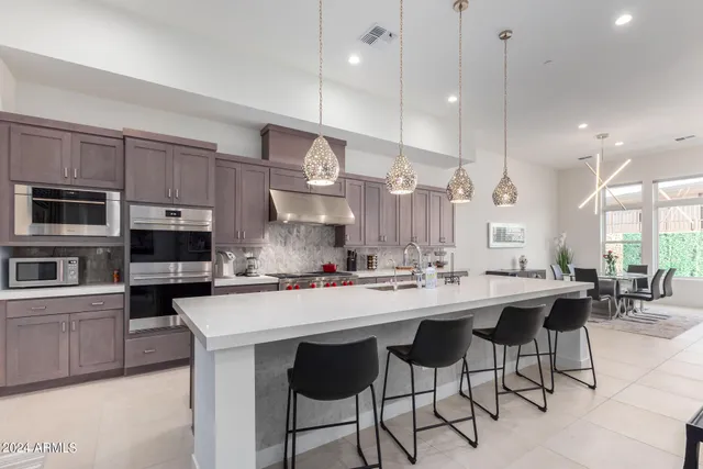 a kitchen with stainless steel appliances a stove a sink and cabinets