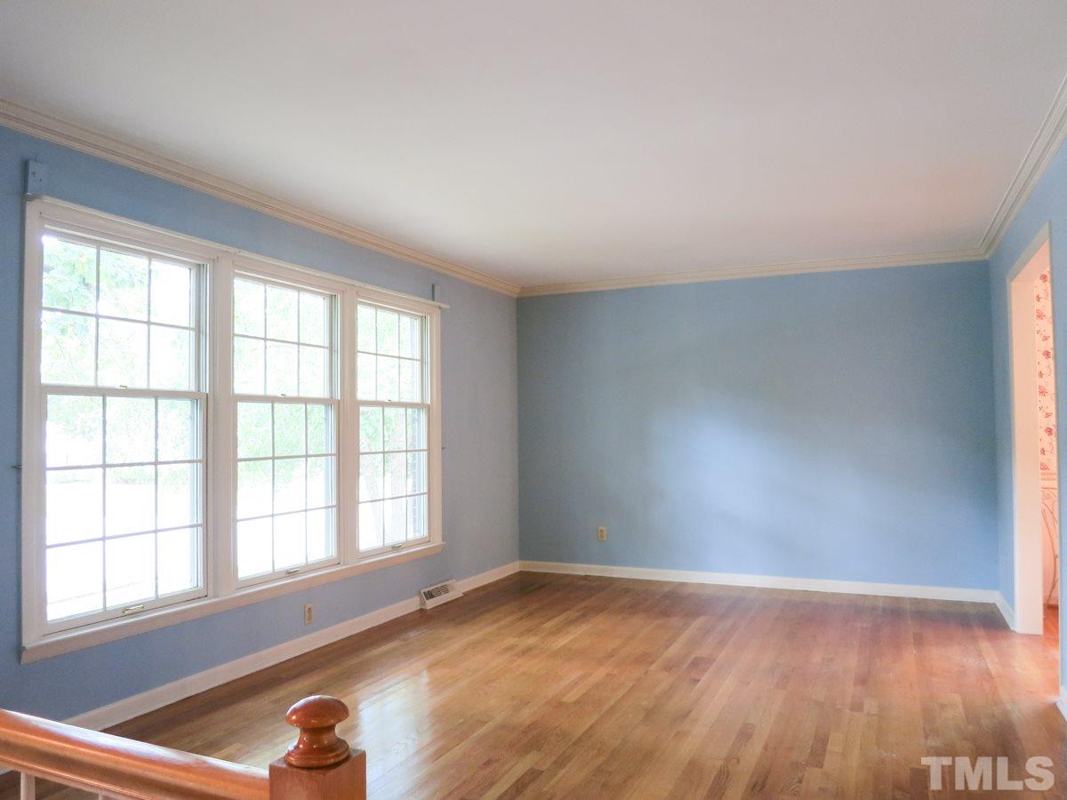 4701 Latimer Road Raleigh, NC 27609 - Photo 3 of 25 The lg main level Living Rm offers hardwood flr, crown molding & triple windows and it opens to the Dining Rm.