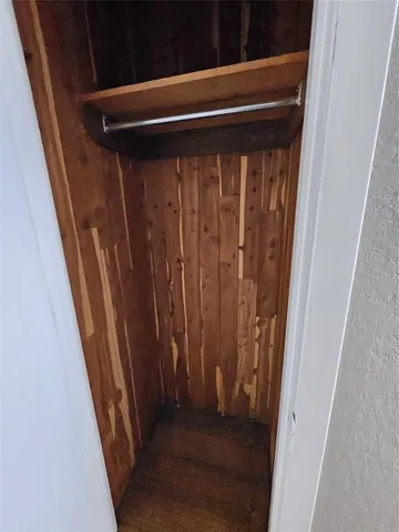 an empty room with wooden floor and cabinets