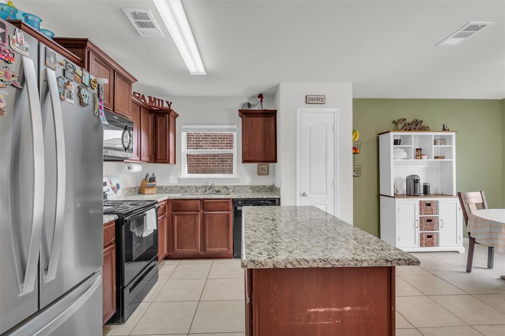 1911 Pilot Point Way Princeton, TX 75407 - Photo 11 of 23 a kitchen with stainless steel appliances granite countertop a sink stove and refrigerator