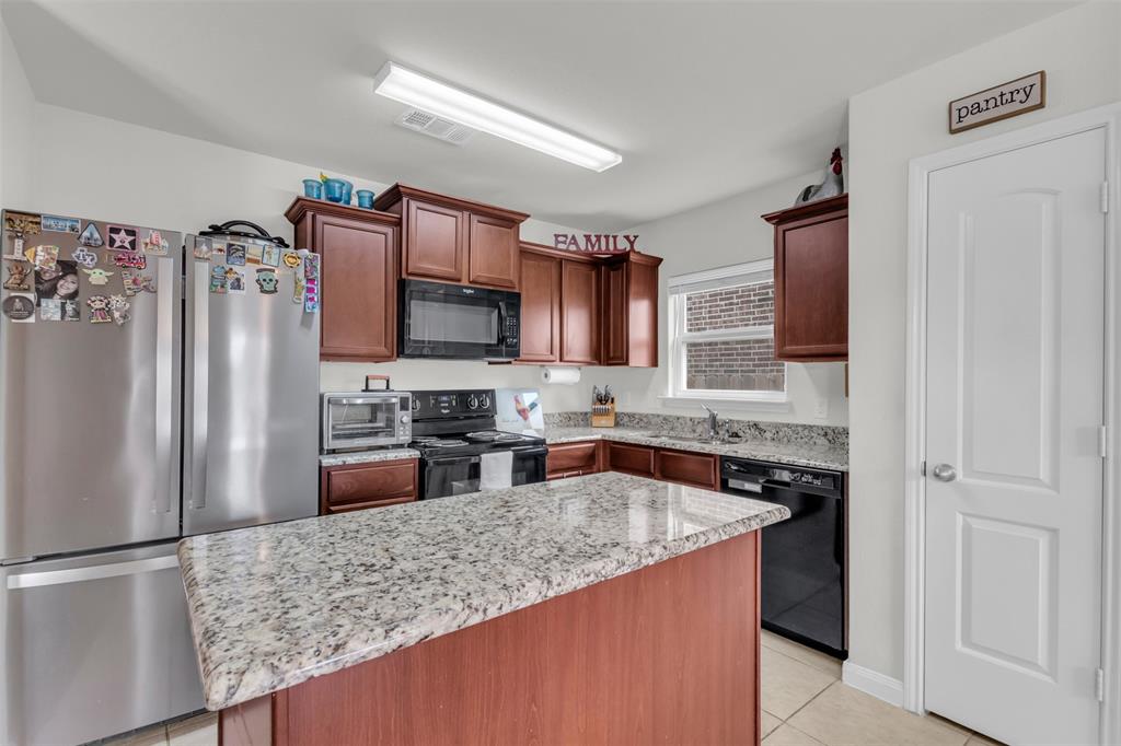1911 Pilot Point Way Princeton, TX 75407 - Photo 12 of 23 a kitchen with stainless steel appliances granite countertop a refrigerator stove and sink