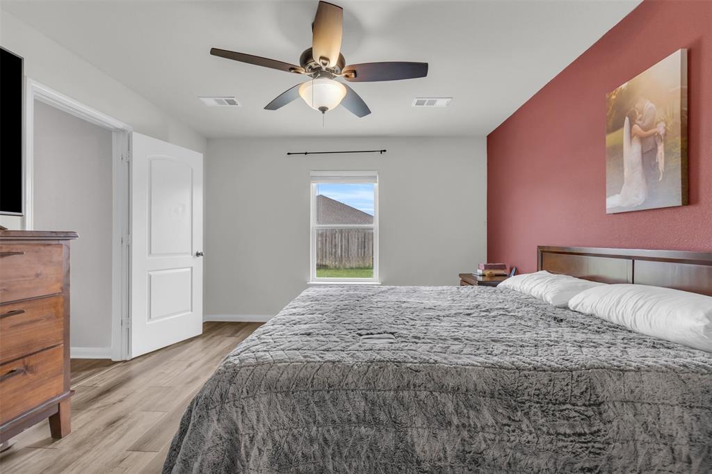 1911 Pilot Point Way Princeton, TX 75407 - Photo 2 of 23 a bedroom with a large bed and a chandelier