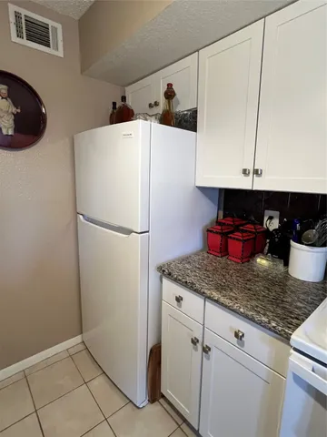 a kitchen with refrigerator and cabinets