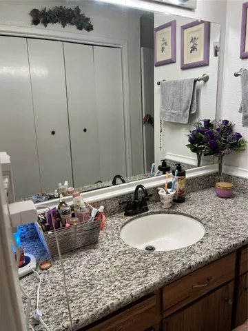a bathroom with a granite countertop sink and a mirror