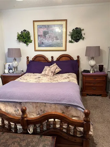 a bedroom with a bed and a painting on the wall