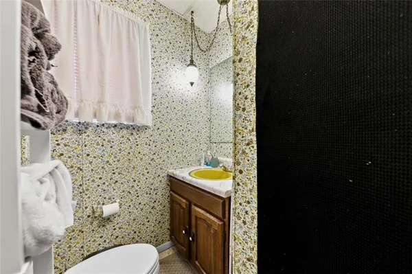 a bathroom with a toilet sink and mirror