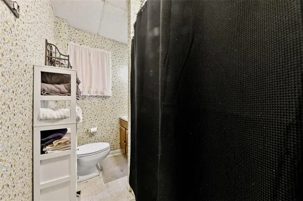 a bathroom with a toilet a sink and mirror