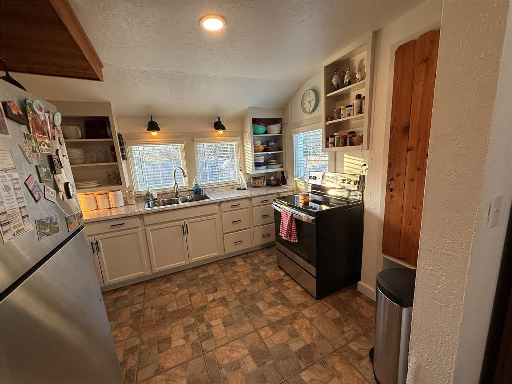 407 South Reagan Street Hamilton, TX 76531 - Photo 13 of 39 a kitchen with stainless steel appliances granite countertop a stove sink and cabinets