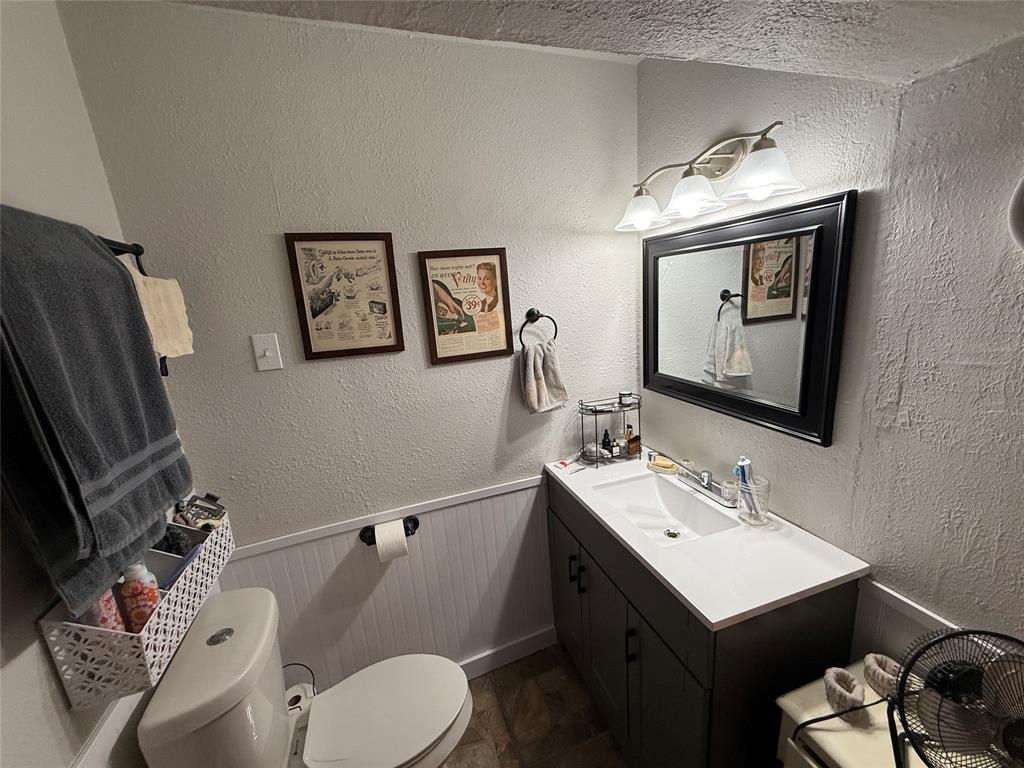 407 South Reagan Street Hamilton, TX 76531 - Photo 25 of 39 a bathroom with a toilet sink and mirror