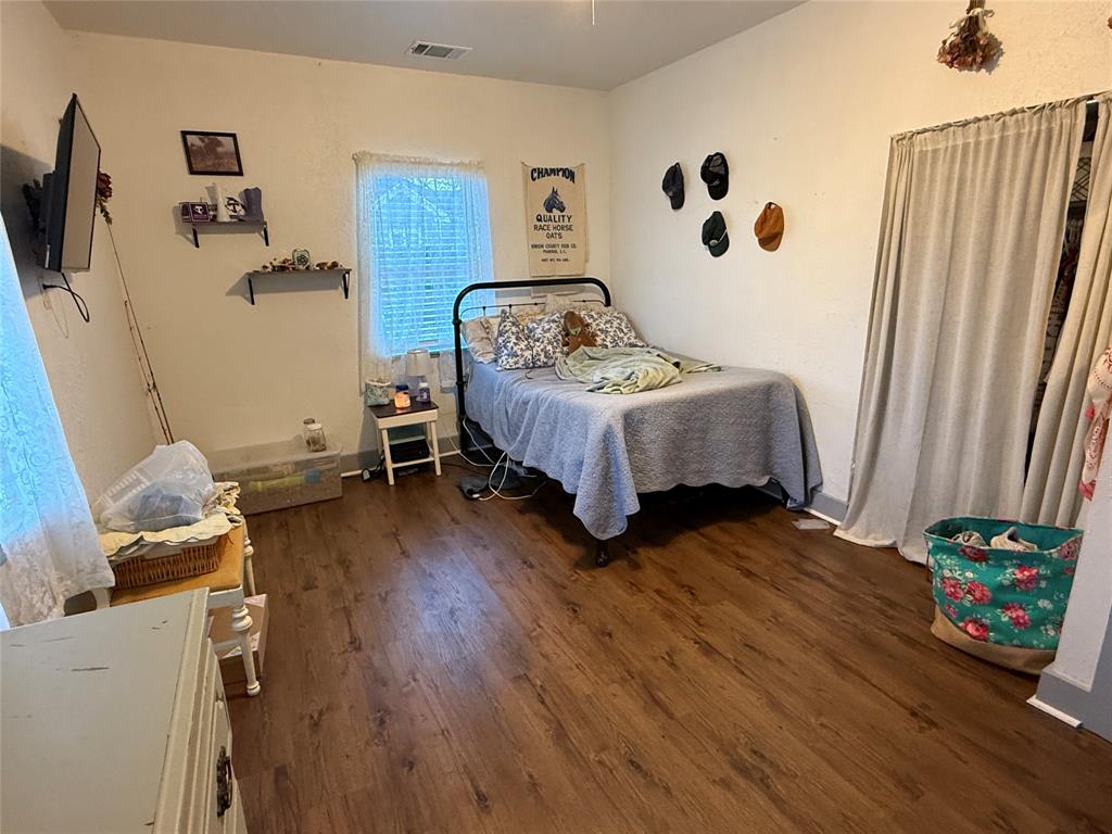 407 South Reagan Street Hamilton, TX 76531 - Photo 27 of 39 a bedroom with a bed and wooden floor