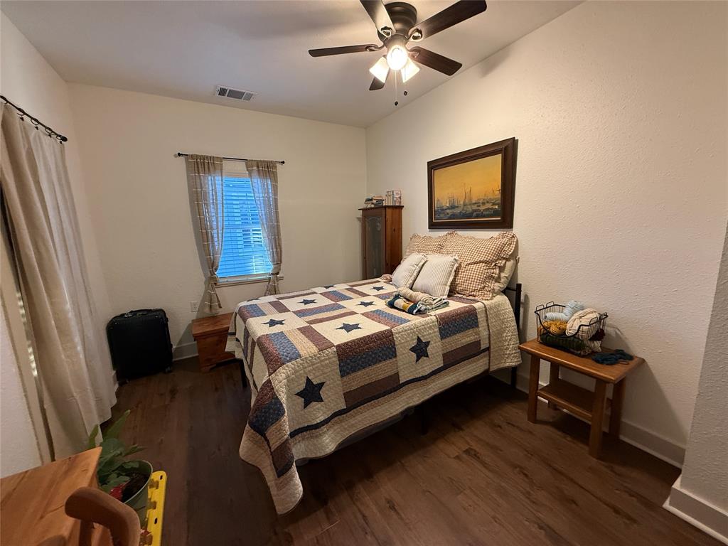 407 South Reagan Street Hamilton, TX 76531 - Photo 29 of 39 a bedroom with a bed and wooden floor