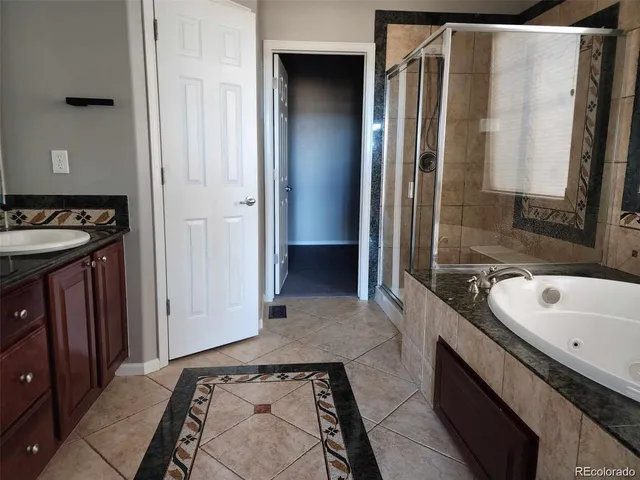 a bathroom with a tub sink and mirror