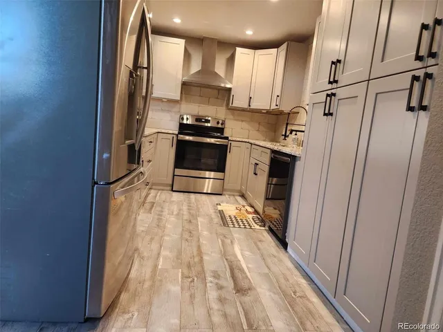 a kitchen with stainless steel appliances a refrigerator and a stove top oven