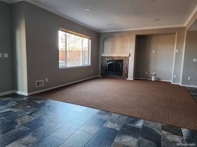 a view of an empty room with a fireplace and a window